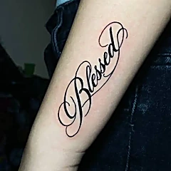 Lettering en caligrafía con la palabra Blessed en un antebrazo