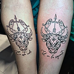 Dos antebrazos con el mismo toro ornamentado y las frases En esta vida y Y en la siguiente